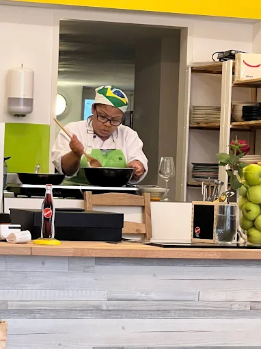In der offenen Küche des D'ouro wird frisch gekocht, mit brasilianischer Flagge auf der Kochmütze