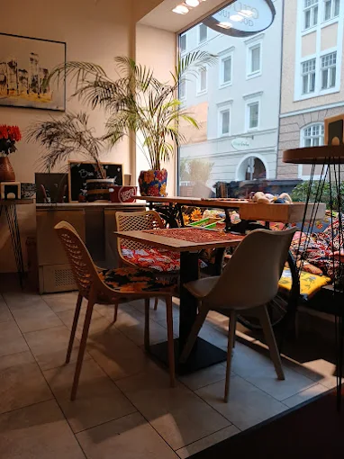 Tisch am Fenster mit Palme und Blick auf die Salzburger Altbaufassaden